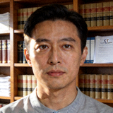 C7官方平台合规负责人人物头像照片，浅灰上衣，背景为书架